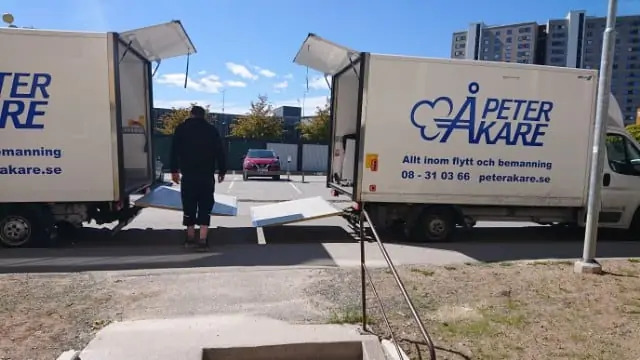 En person står mellan två öppna flyttbilar från Flyttfirma Peter Åkare AB