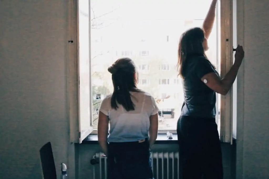 Två personer rengör fönster under flyttstädning