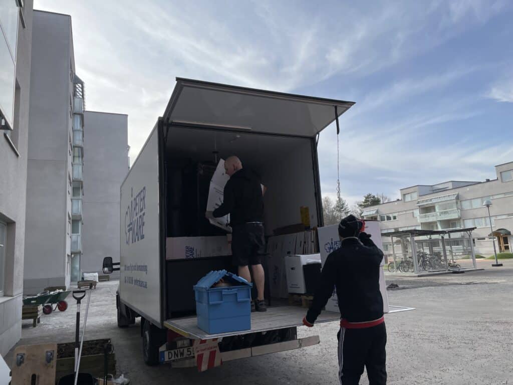 Flyttpersonal från Flyttfirma Peter Åkare lyfter in möbler i flyttbil i Järfälla.